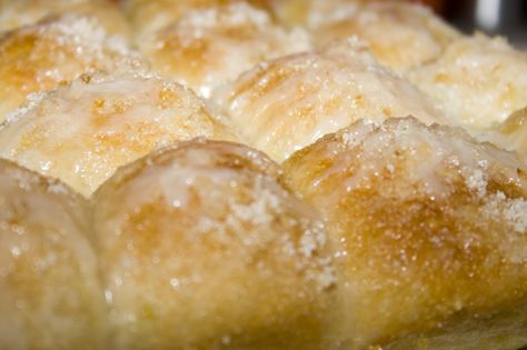 Lemon Monkey Bread  (from Creations by Kara)  12 Rhodes dinner rolls, thawed but still cold  zest of 1 lemon  1/2 cup sugar  3 tablespoons butter, melted  Glaze:  1/2 cup powdered sugar  1 Tbsp lemon juice  1. Cut rolls in half and place in a greased 9×13″ pan.  2. Drizzle with the melted butter.  3. Mix lemon zest and sugar together in a small bowl. Sprinkle HALF of the lemon sugar mixture over the rolls. Cover and let raise till doubled.  4. Sprinkle remaining sugar mixture on top. Bake at 350 Lemon Monkey Bread, Rhodes Rolls, Pull Aparts, Yeast Recipes, Dream Food, Recipe Dessert, Lemon Flavor, Monkey Bread, Sweet Rolls