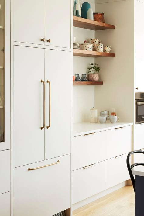 The white cabinetry runs the full height of the wall with ergonomic drawers along the bottom that offer smart storage solutions. Both the uppers and lowers are painted a creamy, warm Silver Satin white from Benjamin Moore so they fade away into the wall. The cabinets are also flat panelled so the absence of lines and details adds to the simplified feel and allows the millwork to look more like furniture than cabinetry. Photos: @naomifin Cabinets:lucvaakitchens Hardware: myohamerica White Wall Cabinets Kitchen, Flat Cream Kitchen Cabinets, White Flat Cabinets, Flat Cabinet Hardware, Cream Flat Panel Kitchen Cabinets, White Kitchen Flat Cabinets, Hardware For Flat Panel Cabinets, Built In Kitchen Cabinets Modern, Flat Panel White Kitchen Cabinets