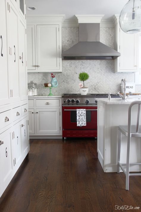 Love this red stove with white cabinets and marble backsplash kellyelko.com #kitchen #kitchendecor #kitchendesign #whitekitchen #appliances #ovens Kitchen With Red Stove, Red Stove In Kitchen, Red Stove Kitchen, Marble Herringbone Tile, Kitchen Counter Storage, Stove Kitchen, Marble Herringbone, Red And White Kitchen, Classic White Kitchen