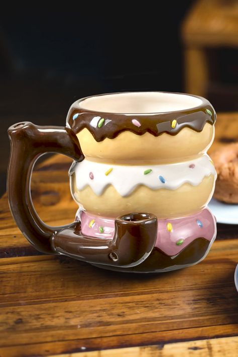 This fun novelty adult gift mug features a Donut design in bold colors. Attached to the side of the mug is a pipe where you can pack your tobacco and light it. The smoke filters up to the mouthpiece on the top of the handle. The trendy Donut mug and pipe is fully functional and comes packaged in a color gift box. This product is recommended for adult use only. Weird Mugs, Donut Design, Delicious Donuts, Novelty Mugs, Gifts For Adults, Color Box, Gifts In A Mug, Morning Coffee, Bold Colors