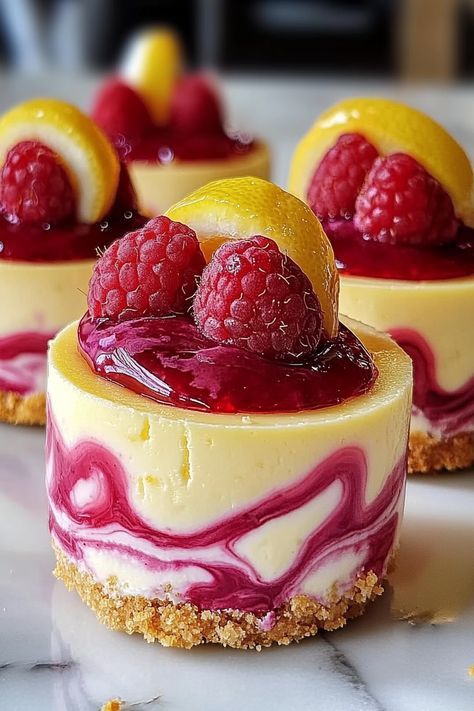 Indulge in these delightful Lemon Raspberry Cheesecake Cups! With a golden Oreo crust, a luscious cream cheese filling infused with tangy lemon zest, and a vibrant raspberry swirl, each bite offers a perfect blend of creamy richness and fruity sweetness. Bake them in muffin tins for easy serving and enjoy chilled for the ultimate refreshing treat. Perfect for impressing guests or satisfying your sweet tooth! #Cheesecake #DessertRecipes #LemonRaspberryDelight Lemon Raspberry Cheesecake Cups, Golden Oreo Crust, Fruity Dessert Recipes, Lemon Raspberry Cheesecake, Raspberry Swirl Cheesecake, Individual Cheesecakes, Food Decoration Ideas, Cheesecake Ideas, Golden Oreo