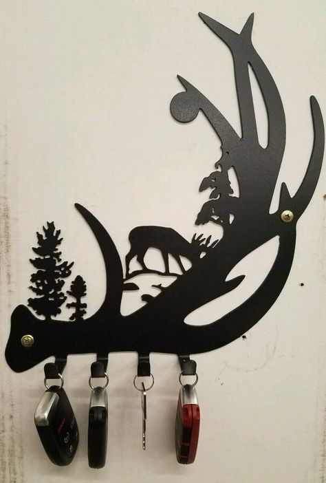 The majestic Whitetail Deer is represented here with an antler in the moonlight. It'll also hold your keys! This design is crafted out of cold rolled steel and plasma cut. This one has a black hammered finish but is also available in any color or torch patina. Great decoration to hang pretty much anywhere. Great gift idea as well. Size is roughly 10x10". MADE IN THE USA!!! If you would like a different size or color or anything custom made or personalized please contact me with your needs. See m Welding Art Ideas, Antler Keychain, Cool Welding Projects, Sheet Metal Art, Scrap Recycling, Rustic Metal Wall Art, Cold Rolled Steel, Keychain Holder, Welding Art Projects