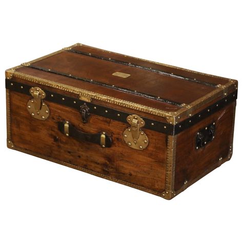 Rectangular in shape and finished on all four sides, this beautiful travel trunk would make an elegant coffee table. Crafted in Paris, France circa 1890 by Pierre de Man in the style of Louis Vuitton, the fruitwood trunk with iron side handles, features decorative brass mounts in the corners, metal straps and wood bands around the front, top and sides; it is further decorated with patinated iron straps around the edges. The chest is dressed with brass nail heads, a front leather handle, and a decorative triple lock mechanism on the facade. The inside is upholstered with white muslin fabric, and the facade is further embellished with a plaque of provenance which reads: "Fabrique d'Articles de Voyage, Maroquinerie, Pierre de Man, 44 rue du Marche, Lille"". The versatile blanket chest is in e Trunks Luggage, Trunk Luggage, Iron Straps, Wicker Trunk, Elegant Coffee Table, Leather Trunk, Antique Trunk, Travel Trunk, Trunks And Chests