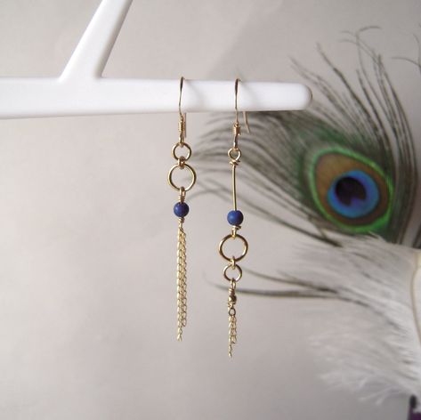 "These mismatched earrings are part of the \"Comète\" collection. They are created in gold-filled yellow gold and genuine Lapis Lazuli pearls. The fine dangling chains represent the tail of a comet hurtling along the edge of the universe... The combination of gold and the deep blue hue of Lapis Lazuli works beautifully.  They are asymmetrical to bring a touch of originality to the classic gold earrings.  This pair of earrings is also available in rose gold and white mother-of-pearl pearls, right here : https://www.etsy.com/fr/listing/1614520595/boucles-doreilles-asymetriques-et?click_key=b777fc9fb019e88954f0b046d089bada0a01e67b%3A1614520595&click_sum=50aeb6e5&ref=shop_home_active_1&frs=1 What is gold filled? It is a metal combining a brass base covered with a thick layer of gold, about 25 Pearl Bead Earrings, Elegant Blue Earrings With Ear Wire, Cute Earring Ideas, Mismatch Earrings, Making Earrings, Unique Diy Earrings Ideas, Asymetrical Earings, Blue Lapis Lazuli Jewelry With Ear Wire, Asymetrical Earrings