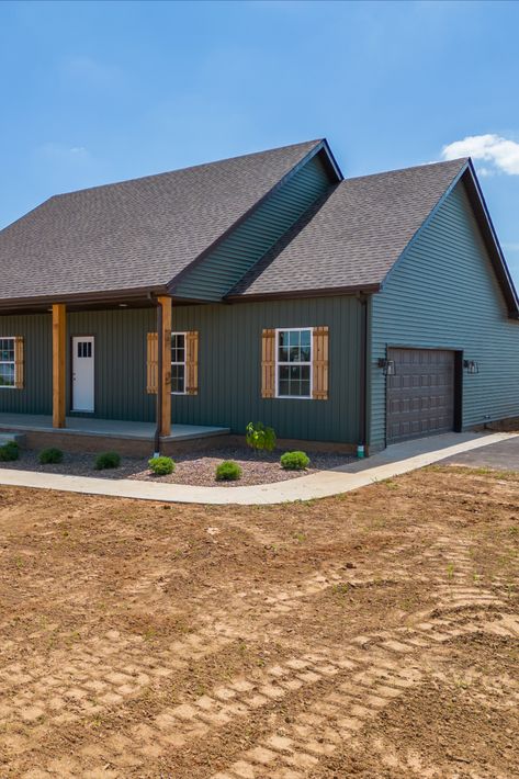 Spruce up your siding and go bold! Dark green siding (color Spruce) with cedar and black accents. Big fan of the dark exteriors. Dark Green Bungalow Exterior, Dark Exterior Colors For House, Dark Green Home Exterior Color Combos, Green Board And Batten Vinyl Siding, Green Siding With Wood Shutters, Dark Green House White Windows, Dark Houses With Cedar Trim, Brown Roof Green Siding, Green Siding House Exterior