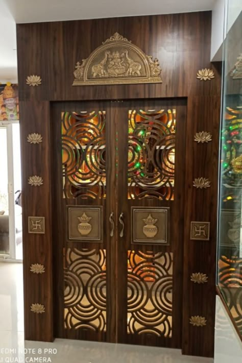 Artisticks pooja room door accessories are the best companions for the perfect pooja doors, which bring an artistic touch along with a traditional look. Our stunning range of pooja room doors designs is sure to give you designs that fit your desires. Accessories are arranged from the top to bottom of the Pooja doors and are equally spaced, making them symmetric and beautiful. #poojaroomdoor #poojadoor #poojaroomideas #poojadoorideas #Poojaroom Ashtalakshmi Pooja Door Design, Chettinad Pooja Room, Unique Pooja Room Door Design, Pooja Room Top Design, Puja Room Door Design Indian Traditional, Pooja Room Door Design Glass And Wood, Traditional Main Door Design Indian, Pooja Room Inside Design, Pooja Door Design Modern