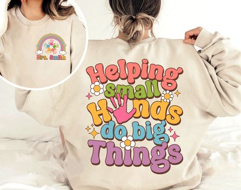 "Teacher Shirt, Helping Small Hands Do Big Things Shirt, Preschool Teacher, Kindergarten Teacher, Back To School, Teacher Appreciation Gift ↓ Click here to view our additional fashionable collections ↓ https://handcraftedbyhelenn.etsy.com Product Details: - 100% Cotton (fiber content may vary for different colors) - Medium fabric (5.3 oz/yd2 (180 g/m2)) - Classic fit - Tear away label - Runs true to size Care instructions: - Machine wash: warm (max 40C or 105F); - Non-chlorine: bleach as needed; Preschool Staff Shirts, Cute Preschool Teacher Shirts, Preschool Tshirt Ideas Teacher Shirts, Preschool T Shirts For Teachers, Preschool Teacher Tshirts, Gifts For Kindergarten Teacher, Daycare Teacher Shirts Designs, Prek Teacher Shirts Designs, Kindergarten Shirts For Teachers