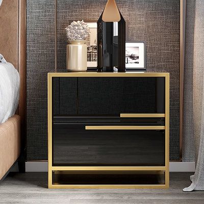 The contemporary nightstand, which is alive with modern beauty and a fashion design, adds a touch of luxury to any bedroom. The color combination which includes a black surface and gold base, seems sumptuous and handsome, keeping with its high quality. This contemporary nightstand will provide a fresh look to your bedroom. This nightstand has a high gloss paint surface that is simple to maintain and clean and provides you with an exquisite fashion appearance. Therefore, it is an excellent choice Black Nightstand Bedroom, Nightstand Minimalist, Gold Nightstand, Minimalist Nightstand, Glam Bedroom Decor, Gold Bedroom Decor, Metal Nightstand, Black Nightstand, Drawers Bedroom