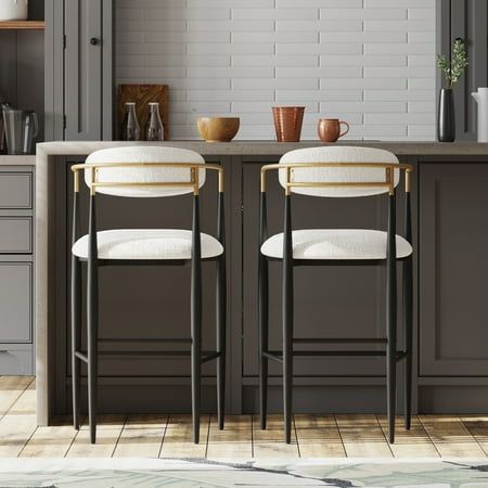 Practicality and sophisticated style collide to create our breathtaking barstool set. These two modern stools are incredibly captivating with their luxe, soft upholstery, toothpick designs, and eye-catching silhouettes. Durable black iron frames with gold accents give these chairs all the glamorous flair your space might be lacking, and open backrests complete the artistic look. Their striking design is sure to complete any carefully-curated space. Enjoy every part of your home and ensure that e Black White And Gold Kitchen Bar Stools, Black Counter Chairs, Island Barstools With Backs, Modern Island Chairs, Black And Gold Counter Stools, Modern Barstools In Kitchen With Backs, Modern Kitchen Island Stools, Basement Bar Stools, Island Kitchen Stools