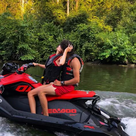 Couple wearing matching red swimsuits sit on jetski, in the background is a river with lots of trees and a pretty sunset. Water is calm and it is summertime. Couples On Jetski, Jetski Couple, Jet Ski Couple, Pics To Take With Boyfriend, Lake Jetski, Twd Carl, Couple Vibes, Themed Engagement Photos, Snow Surfing