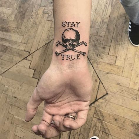 Skull and crossbones with the words ‘stay true’ tattooed on the right wrist by tattooist Annelie Fransson Stay True Tattoo, Skyrim Tattoo, Pirate Skull Tattoos, Skulls Tattoo, Skull Hand Tattoo, Pirate Tattoo, Petit Tattoo, Wrist Tattoos For Guys, True Tattoo