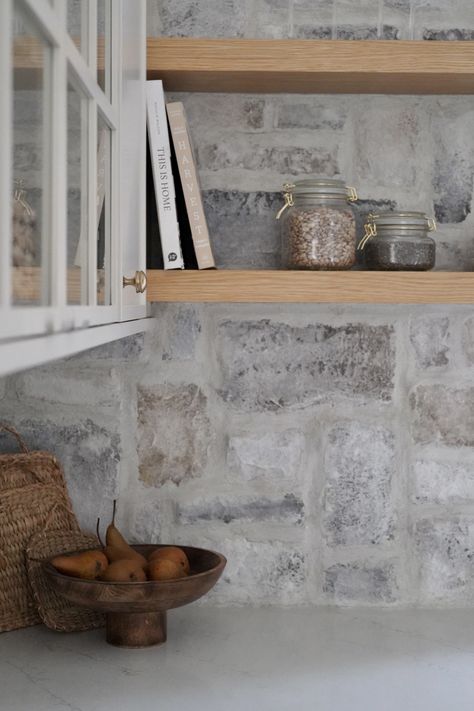 Drawing inspiration from the natural surroundings, we incorporated a stunning natural limestone backsplash around the sink, infusing the space with visual intrigue and timeless charm. Cottage Kitchen Stone Backsplash, Limestone Backsplash Kitchen, Natural Stone Backsplash Kitchen, Full Kitchen Design, Stone Veneer Backsplash, Limestone Backsplash, Kitchen Stone Wall, Stone Kitchen Backsplash, Barndominium Kitchen