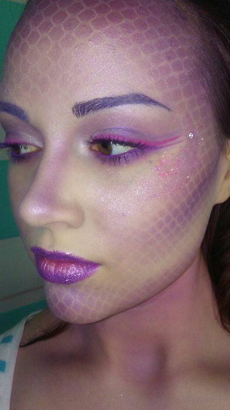 The first rule of mermaid-ing: Don't forget the scales. "I use a mesh wig cap over my face and a dense stippling brush to layer three different purple eye shadow shades," says makeup artist Yasmine Violet (@lifeiswhatyoucakeit). Concentrate the color at your contour and along your hairline, remove the mesh, then add to lids for a mesmerizing monochromatic face. Purple Dragon Makeup, Dragon Scale Makeup, Purple Mermaid Makeup, Mermaid Scales Makeup, Scales Makeup, Halloween Glamour, Disneyland Costumes, Purple Dragons, Mermaid Makeup Halloween