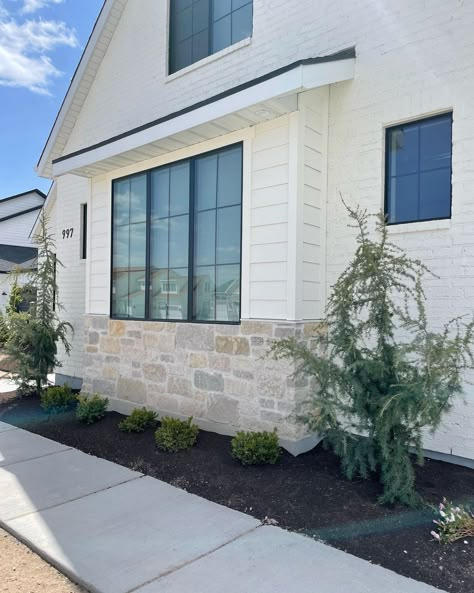 Savannah Feller • Feller House Designs | Such a fan of the colors and materials we used for the exterior of this home. SW Creamy for the brick+siding, and accessible beige on the… | Instagram House Exterior Colors Schemes With Stone, White Brick White Siding Exterior, Shake Exterior Siding, Cream Modern Farmhouse Exterior, Stone On Bottom Of House Exterior, White House With Stone Accents Exterior, Sandstone Exterior Houses, White House With Brick Skirting, Painted Brick And Stone Exterior