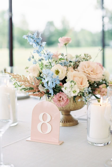 Reception tables popped in baby pinks and blues, while the watercolor crest guest favors created by Stacey Himmel Stationery tied the tablescape together. Dusty Blue And Pink Table Setting, Blue Pink Flowers Wedding, Pink Blue Table Setting, Table Set For Wedding, Candle With Flowers Centerpieces, Wedding Guest Table Flowers, Wedding Table Flowers Pink, Pink And Blue Flower Centerpieces, Blue And Pink Flowers Wedding