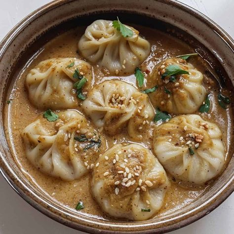 I am sharing a beloved Kathmandu Jhol Momo recipe that transports me straight to the lively streets of Kathmandu. These delicious dumplings are a staple street food in Nepal. Jhol momos are simply momo dumplings served with a delicious sauce. "Jhol" means liquid, and "achaar" means sauce in Nepali. Nepal Recipes Nepali Food, Chicken Momo Recipe, Jhol Momo, Momo Dumplings, Momo Recipe, Momo Food, Steamed Momos, Fantasy Empire, Chilli Chutney