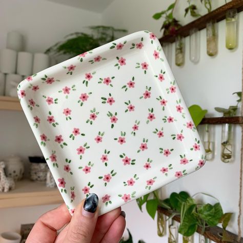 Square trinket tray with little pink flowers 🌸✨🌱 Lots of things available on my website now - link in bio ✨🥰 #art #artist #ceramics #pottery #painting #illustrator #ceramicstudio #potterytiktok #potterypainting #painter #trinkettray #smallbusiness Cute Tray Painting Ideas, Pink Pottery Painting Ideas, Ceramic Trinket Tray, Pottery Tray Painting Ideas, Cute Clay Designs, Jewelry Tray Painting Ideas, Jewelry Plate Painting Ideas, Trinket Tray Painting Ideas, Pottery Painting Trinket Dish