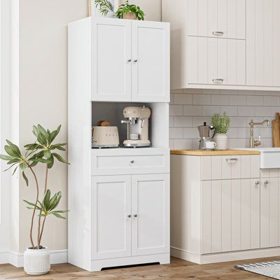 Upgrade your kitchen storage with this stylish and functional pantry. Made from engineered wood and finished in a fresh white hue, it features paneled doors that open to reveal three adjustable shelves for your culinary essentials. The lower drawer provides additional storage space for linens and silverware, while the microwave shelf offers a convenient spot for your handy kitchen appliance. With a weight capacity of 300 lbs. and a tip-over restraint device included, this pantry is designed to k Kitchen Stand Alone Cabinet, Stand Alone Pantry Cabinet, Kitchen Storage Cabinets Freestanding, Kitchen Storage Furniture, Functional Pantry, Small Kitchen Solutions, Food Pantry Cabinet, Standing Pantry, White Kitchen Pantry