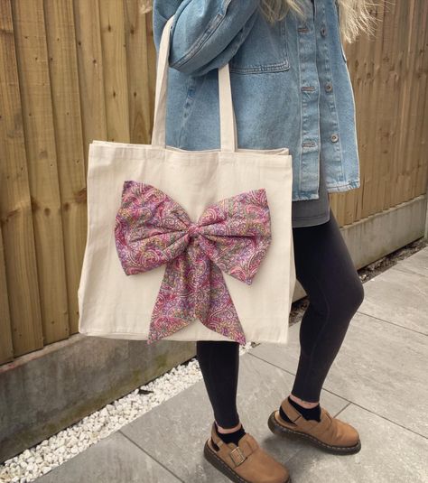 𝘓𝘪𝘣𝘦𝘳𝘵𝘺 𝘉𝘰𝘸 𝘛𝘰𝘵𝘦 𝘉𝘢𝘨𝘴 🌸🌼 Excited to finally share my Liberty Bow Tote Bags! The bows are handmade by me, attached to a canvas tote bag for a more glamorous, stylish look 😍 I made one of these for myself first and got so excited I just had to make more 😂 These will be available from tonight in my Etsy Shop. Currently 4 different fabrics but if they prove popular I may make more varieties. What do you think? Let me know in the comments! And as always, link to my shop in my bio 💐🌻🪻 #liberty #l... Bow Tote Bag, Bow Bag, Potli Bags, Birthday Board, Paisley Floral, Pink Paisley, Handmade Bows, Liberty Of London, Liberty Fabric