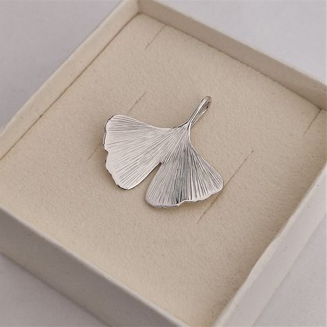 The ginkgo biloba leaf pendant is a handcrafted jewel, entirely made by hand, that captures the elegance and beauty of nature. This unique piece has been created from a sheet of 925 silver, expertly soldered, shaped, and finished with great care and attention to detail. The hand-engraved surface of the leaf, combined with the perfect polished finish of the silver, makes this piece sparkling, refined, and elegant. The ginkgo biloba leaf was chosen as the inspiration for this pendant because of it Ginkgo Leaf Ring, Ceramic Ginkgo Leaf, Gingko Leaf Jewelry, Ginko Necklace, Ginkgo Leaf Necklace, Jewelry Making Classes, Ginkgo Biloba, Heirlooms Jewelry, Metal Clay Jewelry