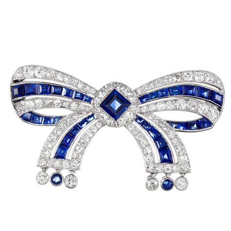 Platinum 1920s bow pin, signed Cartier and set with an EGL-certified no heat sapphire in the center, then further decorated by additional sapphires and 2.50 diamonds. 1.75 by 1 inch. Bijoux Art Deco, Diamond Bows, Bow Brooch, Cartier Jewelry, Bow Jewelry, Diamond Brooch, Royal Jewels, Deco Jewelry, Art Deco Diamond