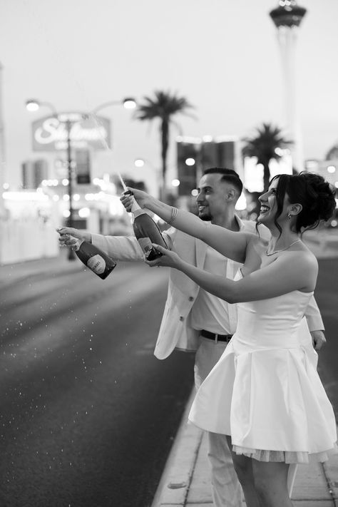 Black and white photo of a bride and groom popping champagne after their Little White Chapel elopement in Las Vegas. See more Las Vegas elopement ideas and Las Vegas elopement aesthetic! Book Kyra as your Las Vegas wedding photographer at riskyexposurephotography.com! Champagne Popping Pictures, Las Vegas Elopement Ideas, Vegas Elopement Ideas, Chapel Elopement, Elopement Aesthetic, Popping Champagne, Little White Chapel, White Chapel, Vegas Elopement