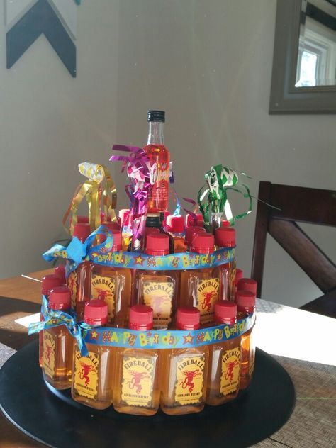 Fireball cake!  made from a charger plate, round foam cake form, and fireball shooters. I added 2 jagers in the middle and a cherry one on top to get a total of 36 shots. (was for a 36th birthday party) hot glue them to the foam and I added ribbon just to be safe Fireball Bucket Ideas, Shooter Cake 21st, Fireball Birthday Cake, Fireball Shooters, Mini Bottle Cake, Fireball Gift Ideas, Fireball Birthday, Fireball Cake, Mini Alcohol Gifts