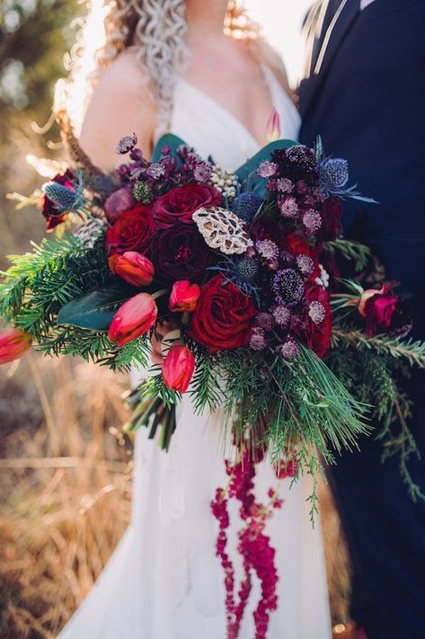 The bride carried a large wintry bouquet of deep reds, greens and jewel tones to match her red lipstick at her winter wedding at 48 Fields in Leesburg, Virginia. #bridebouquet #weddingflowers #jeweltonewedding #winterwedding #modernwedding #virginiawedding Jewel Tone Winter Wedding Flowers, Jewel Tone Cascading Bouquet, Jewel Toned Winter Wedding, Jewel Tone Wedding Winter, Winter Jewel Tone Wedding, Moody Jewel Tone Wedding Flowers, Jewel Toned Bouquet, Winter Jewel Tones, Wedding Winter Colors