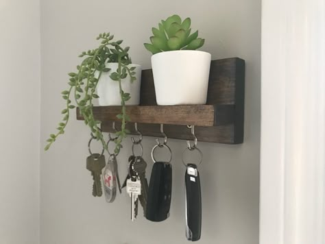 Made this simple key hook for our front entrance. Stained and clear coated. Finished with cup hooks. A couple cute faux succulents sit on shelf. Key Hooks Entryway Diy, Key Hook Ideas, Key Hook Diy, Entrance Hooks, Key Hooks Entryway, Diy Coat Hooks, Key Hook Shelf, Home Hobbies, Hallway Seating