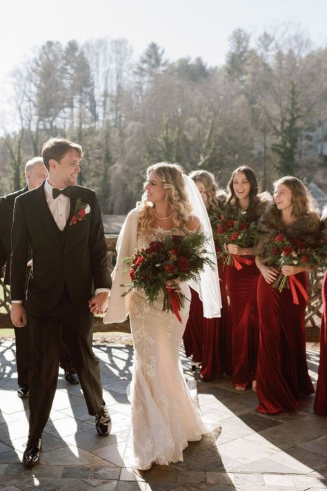 Bride and Groom holding hands in front of bridesmaids wearing red dresses Mother Of The Bride Christmas Wedding, Winter Wedding Party Outfit, Christmas Wedding Ideas Bridesmaids, Christmas Groomsmen Attire, Christmas Wedding Party Attire, Christmas Wedding Bridal Party, Christmas Wedding Attire, Christmas Wedding Photos, Winter Groomsmen Attire