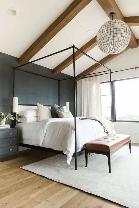 a cozy modern bedroom with a black accent wall, wooden beams on the ceiling, a sphere lamp, a canopy bed and a leather bench Mcgee Bathroom, Iron Canopy Bed, Cozy Bedroom Colors, Canopy Beds, Interior Design Minimalist, Bathroom Baskets, Four Poster Bed, Metal Canopy, Poster Bed