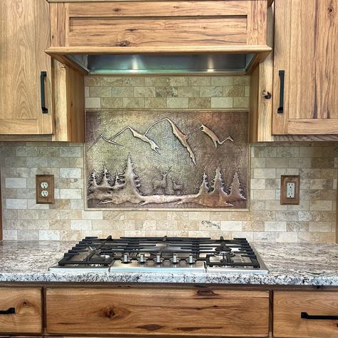 Create a unique and rustic kitchen with our forest scene artwork backsplash. Handmade with real copper, this backsplash pairs perfectly with wood cabinets, adding a touch of nature to your kitchen. Transform your space with our one-of-a-kind design, featuring a serene forest, deer, and stunning mountains and trees. The best kitchen backsplash idea for any nature lover. Backsplash Country Kitchen, Kitchen Backsplash Ideas With Knotty Alder Cabinets, Rustic Backsplash Kitchen, Oven Backsplash Ideas, Kitchen Backsplash With Wood Cabinets, Cabin Backsplash, Wood Backsplash Kitchen, Natural Stone Backsplash Kitchen, Unique Kitchen Cabinets