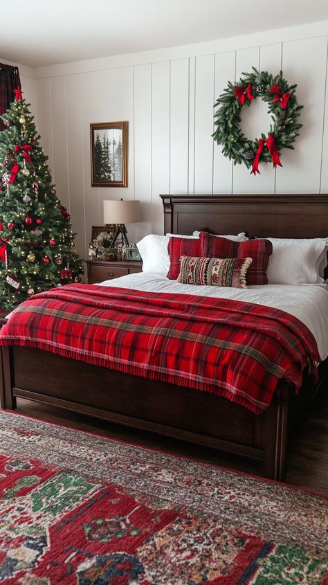 Cozy Christmas bedroom featuring dark wood furniture, a red plaid blanket, festive wreath, and a decorated Christmas tree. Bedroom Decor With Red Accents, Cozy Red Christmas Aesthetic, Green And Red Home Decor, Dark Cozy Christmas Aesthetic, Christmas Bed Ideas, Christmas Master Bed Decor, Christmas Decor Kids Room, White Bedding With Pops Of Color, Red Toile Bedroom