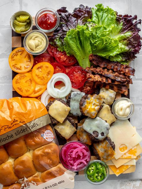 This slider bar is a great way to serve burgers to your family and friends! Load up on toppings, vegetables and condiments. It's so fun! #st.pierre #sliders #burgerbar #briochesliderrolls  howsweeteats.com Burger Slider Bar, Burger Bar Charcuterie, Build Your Own Kabob Bar, Sliders Board Ideas, Slider Bar Wedding, Slider Bar Ideas Parties, Burger Party Ideas Food Bars, Slider Charcuterie Board, Slider Toppings