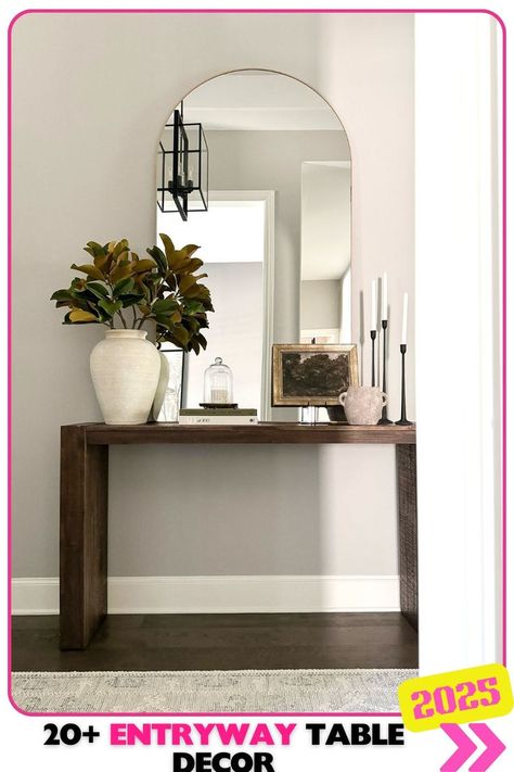 Dark wood entryway table with minimal decor and bold greenery, providing a sleek, modern design for a minimalist yet impactful look perfect for any entryway in 2025. Mcgee Fall Decor, Mirror Over Console Table, Entry Table With Mirror, Entryway Table Styling, Decor Console Table, How To Style A Console Table, Hallway Table Decor, Credenza Styling, Entry Table Decor