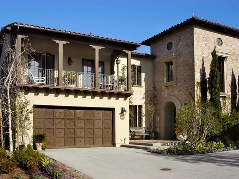 An arched doorway and tile roofs are signature of Mediterranean design. The pillared balcony over the garage provides a sunny sitting area for relaxing. Spanish Garage, Simple Elevation, Arched Entryway, Nice Balcony, Mission Style Homes, Brick Homes, Mediterranean Exterior, Mediterranean Mansion, Garage Exterior