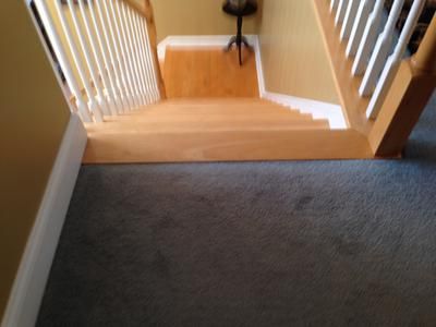 Another thing to do that might help minimize a tripping hazard would be to run the laminate the long way in your hallway so the planks will be perpendicular to the top stair. Description from laminate-flooring-installed.com. I searched for this on bing.com/images Wood Stairs With Carpet At Top, Top Stair Tread Transition, Carpet To Laminate Transition Stairs, Wood Stair To Carpet Transition, Top Of Stairs Floor Transition, Top Stair Transition, Hampton Staircase, Landing At Top Of Stairs, Carpet Landing