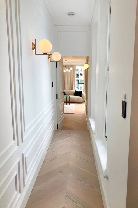 A traditional yet contemporary feel to this newly refurbished property. White panelled walls and light oak flooring complete the hallway lleading down to the guest bedroom.  #whitewalls #panelling #interiorinspo #hallway Panelled Hallway, Light Oak Floors, Living Room Panelling, White Hallway, Hallway Wall Lights, Hallway Inspiration, Narrow Hallway Decorating, Hallway Flooring, Hallway Designs