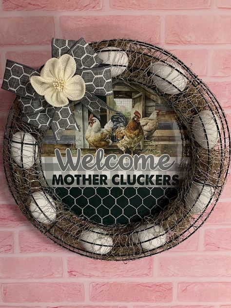 This is a beautiful farmhouse style chicken WELCOME MOTHER CLUCKERS EGG WREATH/DOOR HANGER/WALL DECOR.  This measures approx 14-15" in diameter, it is filled with dried spanish moss and faux eggs, beautifully wrapped in farmhouse chicken wire.  It is decorated nicely with a beautiful bow(which may differ slightly but will be similar to that pictured).  The middle insert with the chicken/Welcome design is metal.  These are made-to-order Diy Chicken Wreath, Chicken Farmhouse Decor, Chicken Wreath Diy, Chicken Egg Wreath, Chicken Wreaths, Chicken Door Hanger, Farmhouse Egg Wreath, Farmhouse Eggs, Chicken Coop Wreaths & Garlands