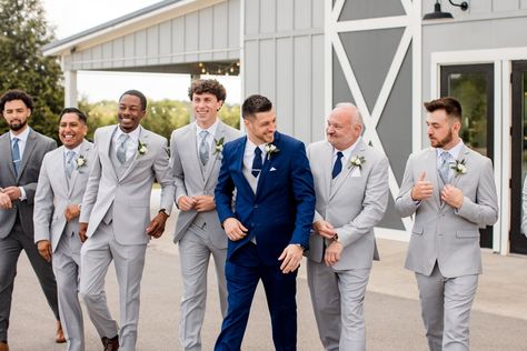 The ultimate wedding party look. With the groom rocking a navy suit and the groomsmen wearing light grey suits with mismatched ties. It made for a truly fun groomsmen vibe perfect for a spring or summer wedding. | John Myers Photography & Videography Navy Groom With Grey Groomsmen, Blue Suit Wedding Party, Grey And Navy Blue Suit, Grey Suit Blue Tie, Navy Blue Suit Wedding, Navy Groomsmen, Gray Groomsmen Suits, John Myers, Groomsmen Poses