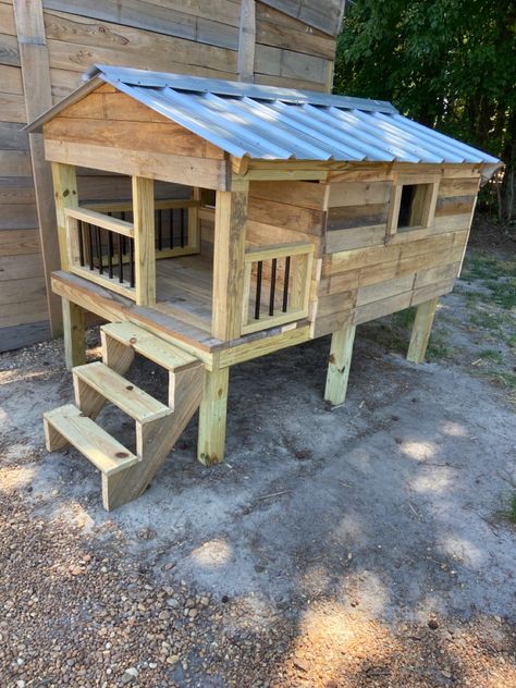 Custom built dog house. Made of treated lumber for frame work. Covering is rough cut cypress. Has a porch with paw rails, a hidden door for wind protection, glass windows, a back door for access for cleaning. Lifted off the ground 2 ft. Outside Dog Houses, Outside Dogs, Frame Work, Dog House Diy, Wind Protection, Outdoor Stuff, Hidden Door, Back Door, House Diy