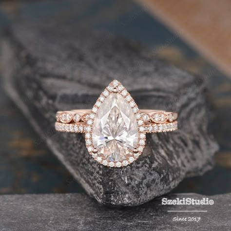 "3.5ct Pear Cut Moissanite Engagement Ring Set Pear Shaped Wedding Ring Rose Gold Bridal Set Tear Drop Halo Ring 8x12mm Moissanite Ring Engagement ring: https://www.etsy.com/listing/619649224 Wedding band: https://www.etsy.com/listing/551290406 6*8mm bridal set: https://www.etsy.com/listing/607354156 ITEM INFORMATION Metal Type - Solid 14k Rose Gold Band Width - (approx. 1.5mm) **Engagement Ring** Center Stone - 8*12mm Moissanite, Pear Shaped Weight- 3.5CT Color- D-E-F Clarity- VVS Side Stone - Tear Drop Engagement Ring Rose Gold, Pear Shape Rose Gold Engagement Ring, Tear Drop Engagement Ring Gold Band, Pear Bridal Set, Tear Drop Wedding Ring Sets, Pear Engagement Ring With Wedding Band Gold, Rose Gold Pear Shaped Engagement Ring, Pear Wedding Ring Set Gold, Pearl Shaped Engagement Ring