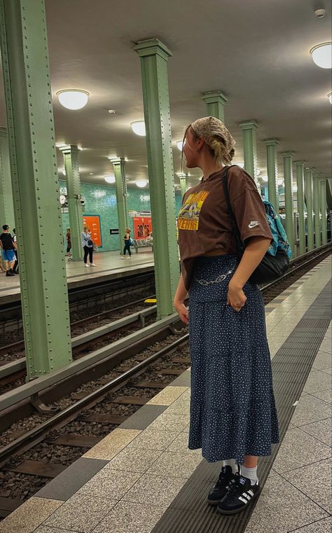 Waiting for the train pose vintage outfit inspo long flowy maxi skirt brandy Melville with adidas sambas and headscarf and silk scarf black leather shoulder purse sneakers vintage vibe in Europe with sambas Sporty Long Skirt Outfits, Long Skirt Outfits With Tshirt, Long Baggy Skirt Outfit, Long Skirt With Baggy Shirt, Toboggan Outfit, Baggy Tee Shirt Outfit, Long Skirt Sneakers Outfits, Flowy Midi Skirt Outfit, Long Skirt Baggy Shirt