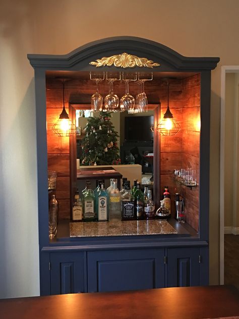 Rustic dry bar conversion from a TV Armoire. The bar top is a unique found piece of glass-embedded resin. #Bar #Repurpose #Drinks #Alcohol #Cocktails #ReclaimedWood #Lighting #Lights #Resin #Glass Bar From Armoire, Armoire Repurpose Bar, Bar Armoire Repurposed, Repurposed Tv Armoire Ideas, Alcohol Cabinet Ideas Rustic, Tv Armoire Repurposed Bar Liquor Cabinet, Upcycled Bar Cabinet, Farmhouse Wine Bar, Armoire Bar Repurposed