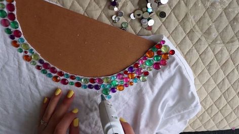 Spruce up your DIY t-shirt by using lovely jewels and embellishments. You can transform a boring t-shirt into a bedazzled DIY t-shirt! Check out this bedazzled t-shirt tutorial to learn more. Bedazzle Tshirt Diy, Add Sequins To Shirt Diy, Diy Rhinestone Shirt Ideas, T Shirt Embellishments Diy Ideas, Diy Bejeweled Top, Diy Bedazzled Shirt, Bedazzle Clothes, How To Bedazzle Clothes, Bedazzled Tshirt