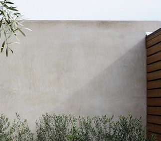 smooth, light grey stucco walls at existing building. Stucco Courtyard Walls, Light Grey Rendered House Exterior, Plastered Garden Wall, Stucco Exterior Wall Fence, Stucco Aesthetic, Exterior Wall Finishes Texture, Limewash Render Exterior, Stucco Fence Wall Modern, Smooth Stucco Retaining Wall