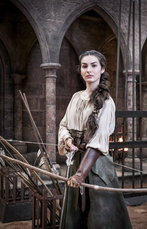 Marina Moschen as Selena de Cáseres in “Deus Salve o Rei” (2018). Bow And Arrow, Medieval Clothing, Long Hair, A Woman, Hair