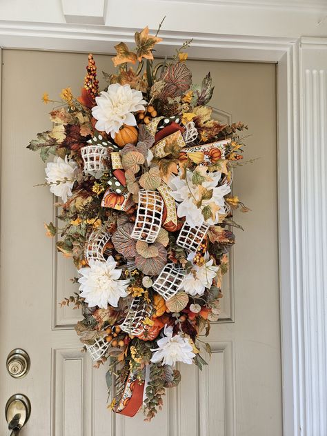 This beautiful autumn design is made on a pine teardrop base with lots of fall goodies, pumpkins, florals, deco mesh, and so much more. A touch of farmhouse and elegant chic is what this one brings to mind, make you door welcoming and grafeful this Fall season. Stop by fallingbranchdesigns.com for more seasonal decor. Deco Mesh Door Swag, Fall Swags For Front Door, Swags For Front Door, Fall Goodies, Teardrop Swag, Fall Swags, Thanksgiving Wreath, Mesh Door, Door Swag