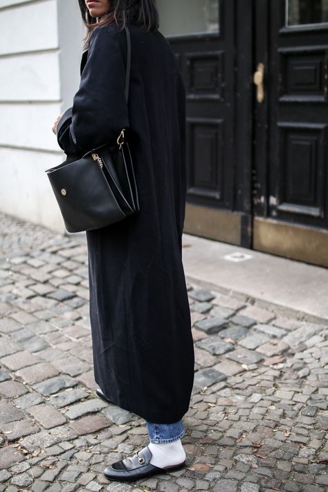 storm wears gucci slipper with white socks a long black coat and chloé faye bag in berlin street style Slipper Loafers Outfit Women, Slipper Mules Outfit, Loafer Mules With Socks, Black Gucci Mules Outfit, Socks With Mules, Gucci Princetown Slipper Outfit, Gucci Loafer Outfits Women, Black Loafers White Socks, Mules With Socks