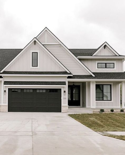 Grey House White Garage Doors, Light Grey Vertical Siding, White Garage Exterior, Tan Black House Exterior, White House Dark Grey Roof, Black Vs White House Exterior, Light Grey Houses Exterior, Exterior House Colors With Light Grey Roof, Light Gray And Dark Gray House Exterior